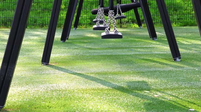 An abandoned school playground; the only swing set sways slowly in the wind.