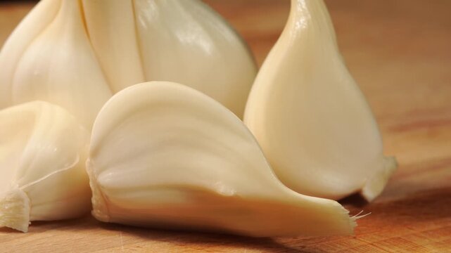 Beauty shot of fresh white young garlic cloves rotating.