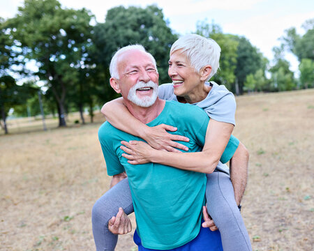 Smiling active senior couple having fun  together in the park, active healthy elderly people bonding, older couple happy relationship