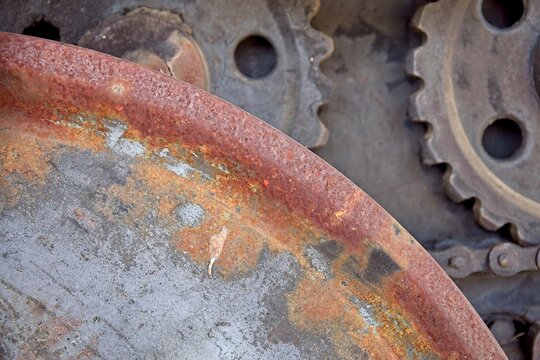 Several old, metallic industrial cogs and gears covered in a significant layer of orange rust, Estonia, Europe.