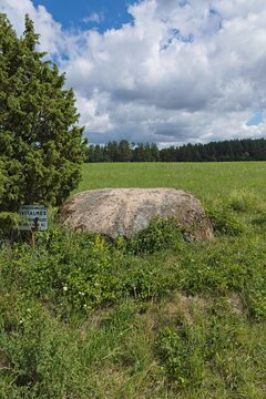 Aljava Kunnati kivi (also known as Ukukivi), the metal sign standing beside it labels it as an officially protected archaeological monument (Arheoloogiam&auml;lestis), Muhu, Estonia, Europe.