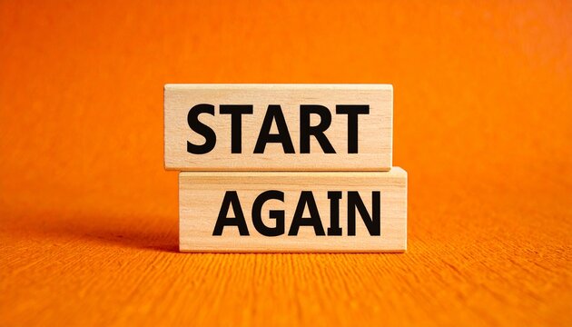 Stacked wooden blocks with start again text on orange background.