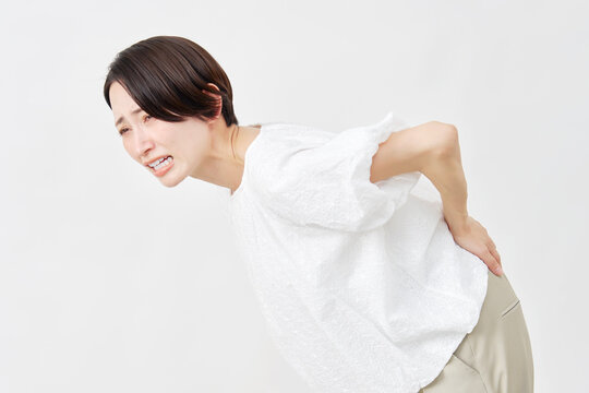 ミドルエイジ女性　腰痛　白背景