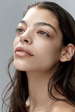 Natural beauty woman oval face smooth skin thick eyebrow full lips wet hair soft light studio portrait