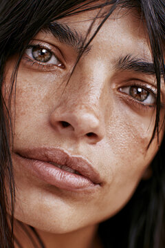 Close up woman face brown eye thick eyebrow natural skin texture oval shape emotional expression