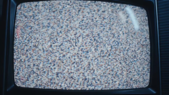 A close-up shot of a vintage television screen displaying static and film strip frames.