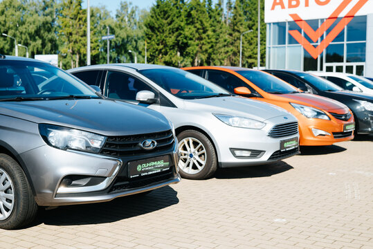 A row of cars is parked at a dealership showcasing different models. The time is during the day and the location features a lot surrounded by trees Smolensk, Russia 07.17.2026