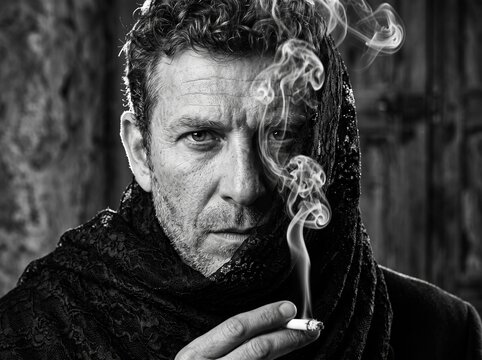 Black and white dramatic portrait of serious mature man smoking cigarette
