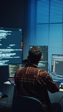 Vertical Screen : Young Caucasian male programmer write code on computer in office at night. AI technology, cybersecurity, software developer, freelance innovation, database system, digital network.