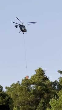 Chopper dropping water on forest fire