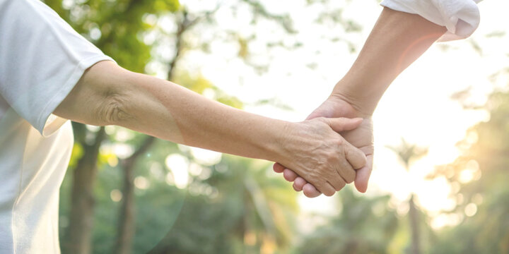 Taking care of the elderly with attention and helping hands gently holding the elderly's hand