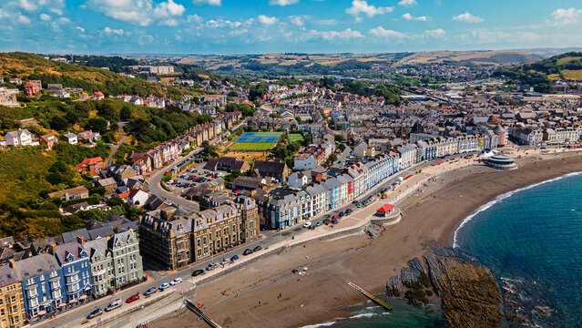 Victorian seafront promenade beach and green hills in aerial view