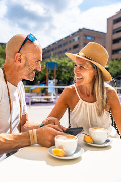 Mature couple enjoying summer coffee break outdoors smiling