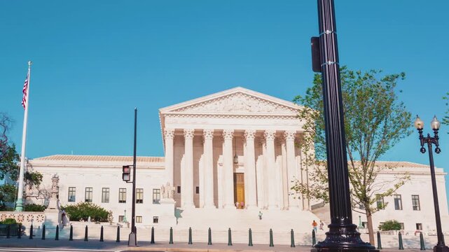 Courthouse Architecture Exterior with Motion Blur People Walking in a City 4k Timelapse Shot Capturing Busy Urban Life with Classical Stone Pillars and Clear Blue Sky