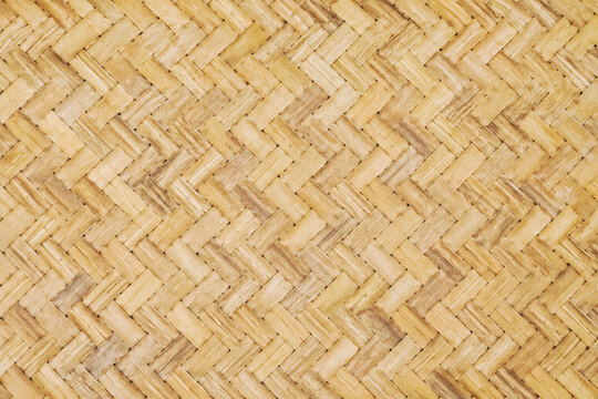 Natural woven bamboo texture with a traditional herringbone weave pattern and warm beige tones. Organic handcrafted surface ideal for wall panels, furniture, tropical interiors, and seamless backgroun