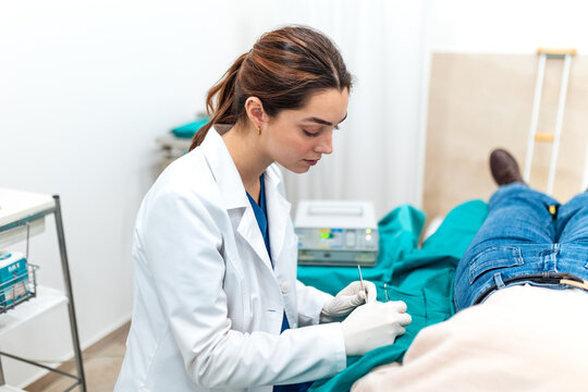 Doctor performing medical procedure in clinic. Female doctor wearing gloves doing minor surgery on patient. Healthcare and medicine. Focused physician working in medical office with instruments.