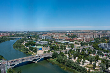 Fototapeta premium Panoramic aerial cityscape view of Zaragoza and Ebro river from top of the Basilica of Our Lady of the Pillar, wide angle cityscape of historic city center, bridges and river bend in Aragon, Spain.