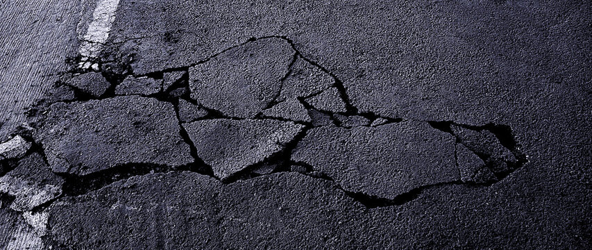 Cracked asphalt pavement with white road line. Damaged and cracked dark asphalt road background, Pavement cracks, Damaged road surface. not ai
