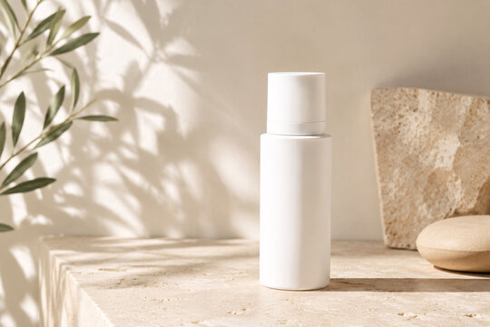 White cosmetic bottle with stone wall and plant shadow detail