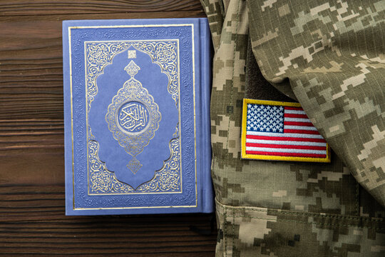 Islamic holy book with Arabic title Al-Quran beside military uniform with the US flag, representing Muslim American veterans, military imams and chaplain support
