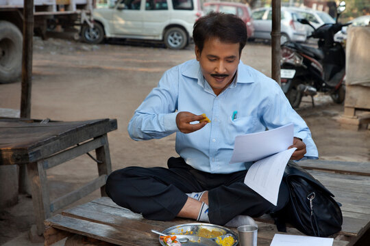 Salesman having lunch and looking into paper work