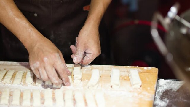 Close Up of Chef Hands Preparing Dough for Fried Bread Sticks