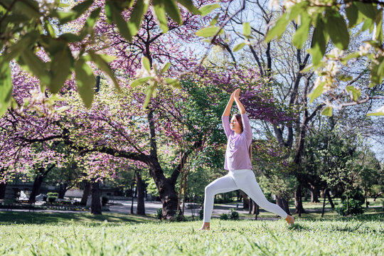 Teenage girl practicing yoga at park in bloom