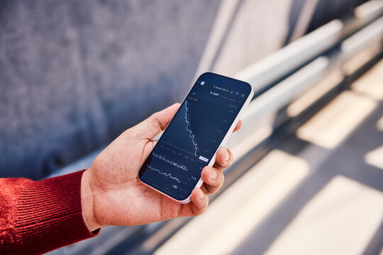 Hand holding smartphone with trading app showing financial loss