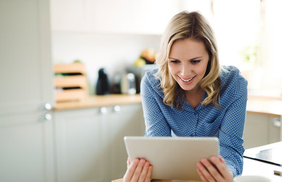 Smiling woman using tablet at home