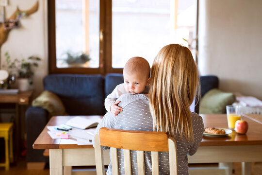 Mother with baby at home sitting at table