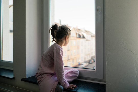 Little girl looking out of window