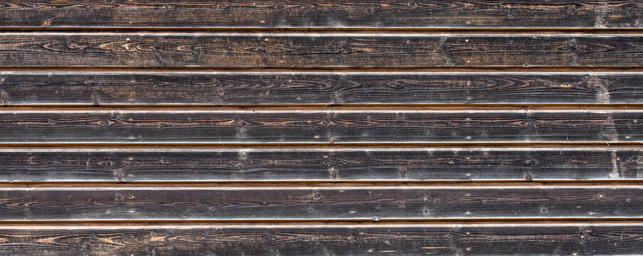 Weathered dark brown horizontal wooden planks texture background with fine grain