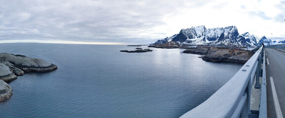Obraz premium Panoramic Road Trip View from Bridge Over Sea and Snowy Mountains, Lofoten Norway