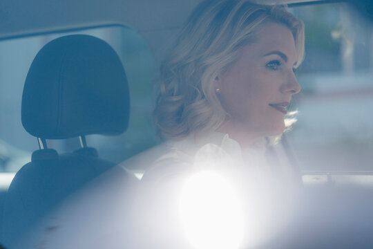 Confident blond woman driving car