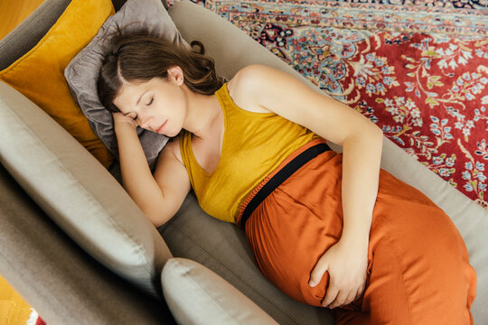 Pregnant woman taking a nap on her couch at home
