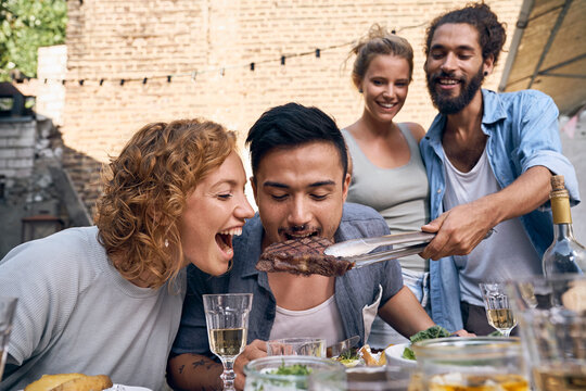 Friends having fun at a barbecue party, eating together