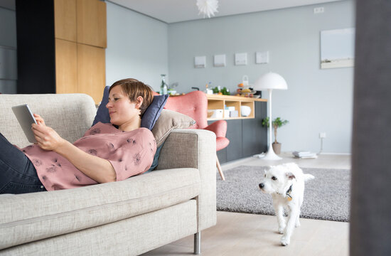 Woman lying on the couch using tablet