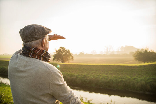 Senior man in rural landscape looking at view