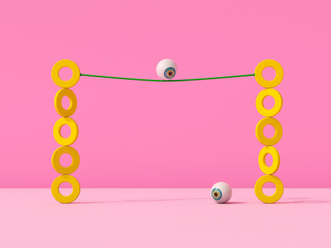 An eyeball balances on a string between yellow rings