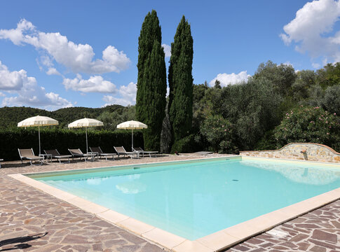 A swimming pool on the Montemassi hillside surrounded by cypresses and oleanders n the province of Grosseto. Italy