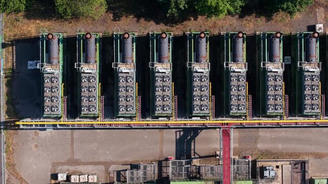 Aerial view looking directly down at rows of containerised industrial generators and high-capacity compressor units lined up inside a Doncaster rail depot yard.
