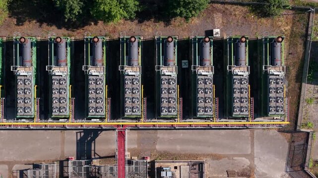 Aerial view looking directly down at rows of containerised industrial generators and high-capacity compressor units lined up inside a Doncaster rail depot yard.