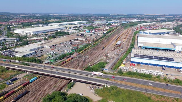 Aerial view of huge railway yard, bridge crossing railway lines, and warehouses in Doncaster