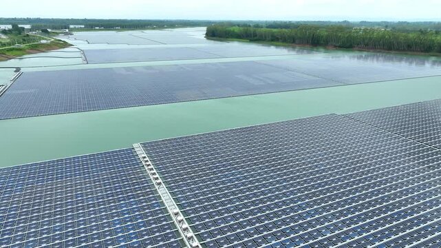 Aerial view of interconnected floating solar panels on water, showcasing sustainable electricity generation, green technology advancement, and efficient use of limited land resources. Thailand. 4k.
