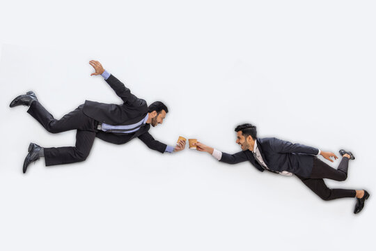 Corporate employees in formal business suit toasting with coffee cups floating against white background.