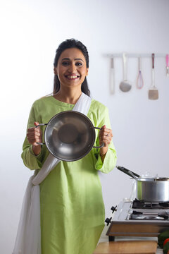 Young woman in salwar showing kadai in front of camera