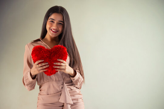 Portrait of a young girl with heart shaped cushion