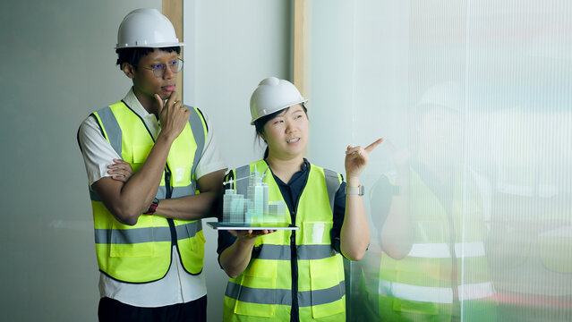 Diverse engineers analyzing 3D city blueprint hologram on tablet for smart architecture project.	