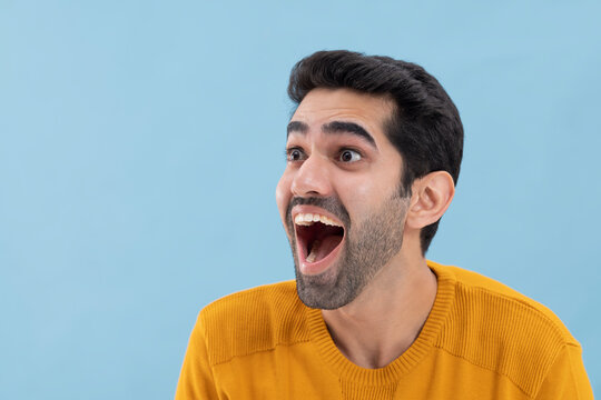 Portrait of a surprised  young man looking away with mouth opened