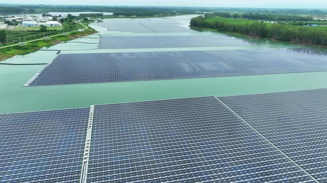 Drone perspective of floating photovoltaic arrays on water, illustrating the combination of renewable energy technology, resource efficiency, and ESG strategies for a low-carbon future. Thailand. 4k.
